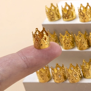 Gros plan d'une perle de cheveux couronne dorée sur le doigt montrant la taille