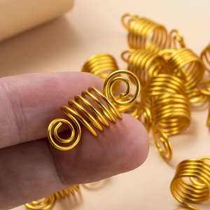 Vue macro de bijoux de cheveux en spirale dorée pour dreadlocks avec design à ressort