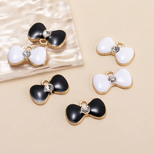 Detail view of bowknot charms with gold frames, enamel inlay, and center rhinestones