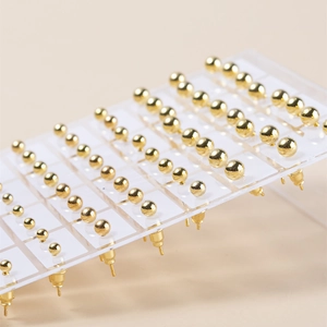 Minimalistische gouden bolvormige oorbellen set op transparante display voor dames