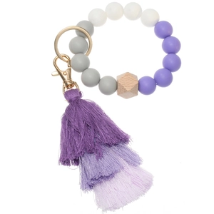 Detail of gradient purple tassel and silicone beads with golden lobster clasp and key ring