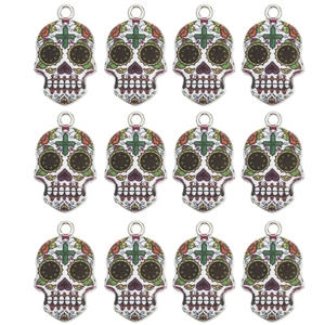 Set of 12 Mexican folk art sugar skull pendants with colorful enamel details on white background