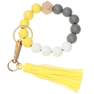 Detail of colorful wooden bead bracelet keychain with yellow leather tassel and gold ring