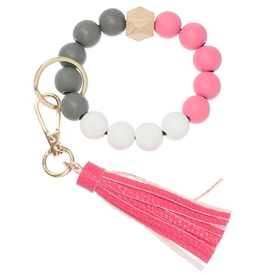 Detail of colorful wooden beads and pink leather tassel on a golden keychain ring