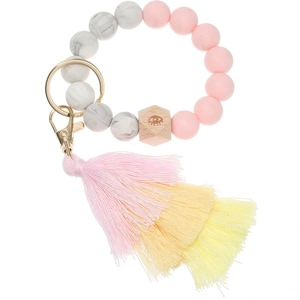 Detail of pink silicone beads and wooden eye charm on a beaded keychain bracelet with tassel