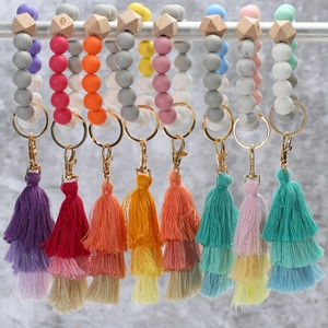 Macro shot of colorful silicone beaded keychain rings with tiered gradient tassels and metal clasps