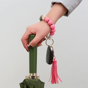 Wristlet keychain with pink silicone beads, wood accent and leather tassel on wrist