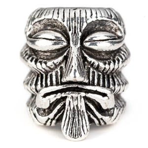 Detailed macro of vintage silver Tiki face alloy bead with embossed relief texture