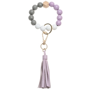 Detail of beaded keychain bracelet with purple leather tassel and wooden beads charms