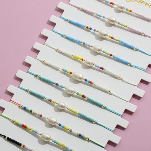 Ensemble de bracelets bohèmes tressés avec perles colorées et perles blanches sur rose