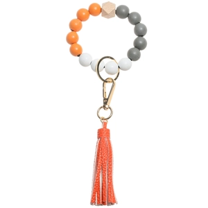 Detail view of colorful beaded keychain bracelet with orange leather tassel and gold ring