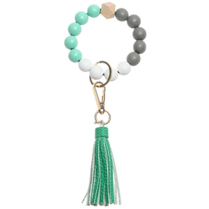 Detail of beaded key ring bracelet featuring mint green beads and long leather tassel