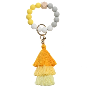 Detail of beaded silicone keychain bracelet with hexagonal wood bead and layered tassel