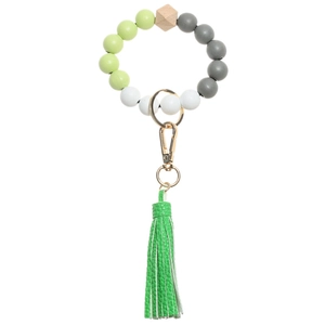 Detail of beaded keychain with green leather tassel and natural wood beads on white background