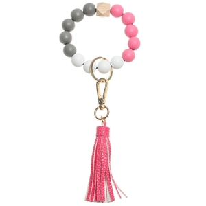 Close-up of wooden bead, pink silicone beads, and leather tassel on keychain bracelet