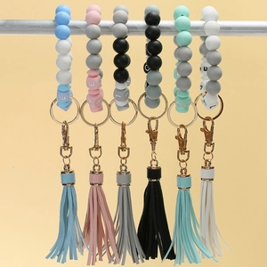Detailed view of silicone bead keychains with letters, gold rings and matching tassels