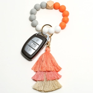 Detail of beaded tassel keychain with silicone beads and car key on white background
