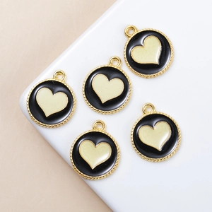 Detailed view of five black enamel heart charms with gold serrated edges for DIY jewelry