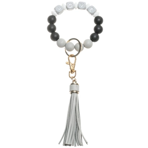 Detail view of LOVE silicone bead keychain with gray leather tassel and gold clasp