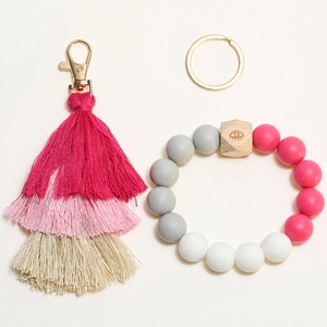 Detail of three-layer gradient tassels with silicone bead wristlet and gold key ring