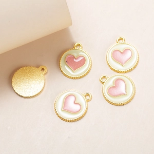 Detailed close-up of alloy enamel heart pendants with gold sawtooth edges and back texture
