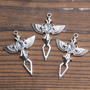 Pendentifs croix épée ailes d'ange en argent avec cristal sur fond bois sombre
