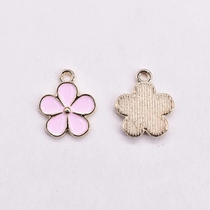 Detail von rosa Emaille-Blumenanhängern mit Goldrand und Aufhängeschlaufen für DIY-Schmuck