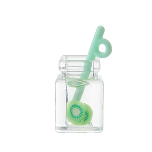 Close-up of miniature resin fruit tea cup with kiwi slices and a mint green stirrer