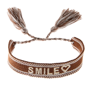 Κοντινή λήψη πλεκτού βραχιολιού με κέντημα SMILE και ρυθμιζόμενο κορδόνι με φούντες