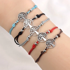 Macro-opname van 5 kleurrijke verstelbare gevlochten armbanden met Tree of Life hangers
