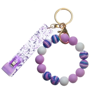 Close-up of purple silicone bead wristlet with glitter card puller and gold metal clip