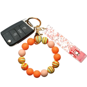 Detail view of colorful silicone bead keychain bracelet with gold lobster clasp and charms