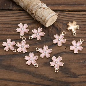 Détail des pendentifs fleur de cerisier en émail rose avec strass pour bijoux DIY