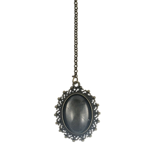 Detail of vintage oval pendant with grey marble resin stone and antique bronze frame