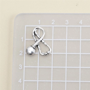Macro shot of silver stethoscope charm on scale showing 1.5cm x 1.7cm size details