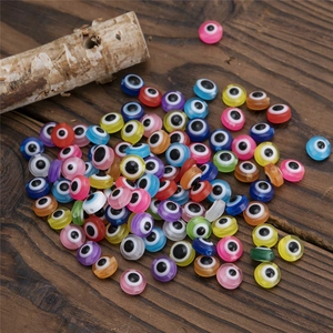 Macro shot of colorful resin Evil Eye beads in mixed colors on a dark wooden background