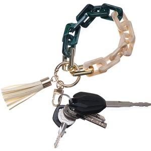 Detail of tortoiseshell acrylic chain keychain with cream tassel and metal hardware
