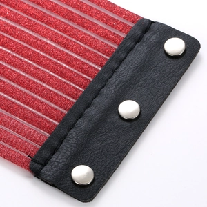 Macro-detail van rode glitterstof met verticale strepen en zwart leer met zilveren studs
