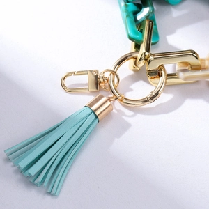 Detail of light blue leather tassel with acrylic marble rings and golden lobster clasp