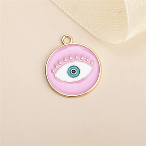 Détail macro du pendentif mauvais œil en émail rose avec finition métallique dorée