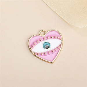 Gros plan d'un pendentif coeur en émail rose avec œil maléfique et perles dorées