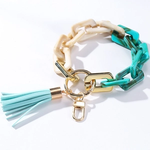 Detail of acrylic chain keychain with cream and green marble links and blue leather tassel