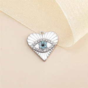 Vue macro d'un pendentif coeur avec œil protecteur et cristaux bleus pour bijoux DIY