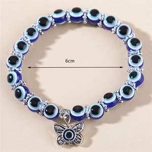 Détail du bracelet perles Oeil du Diable bleu avec pendentif papillon et entretoises