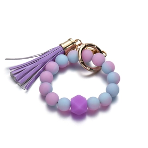 Dettaglio delle perle in silicone sfumate viola e blu con nappa e portachiavi dorato