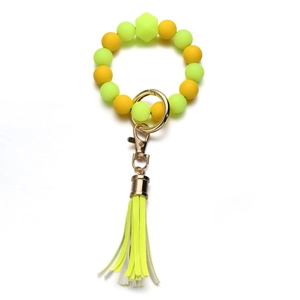 Dettaglio del bracciale portachiavi in perline di silicone neon con nappa in pelle oro