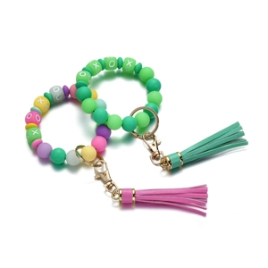 Close-up of silicone beaded keychains with XOXO letters and colorful leather tassels
