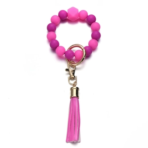 Dettaglio portachiavi con perline di silicone rosa e viola con nappa e anello dorato