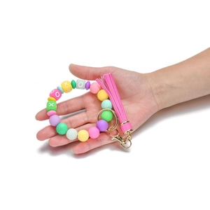 Detail of colorful silicone beaded keychain wristlet with pink tassel and gold clasp