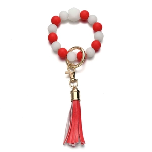 Dettaglio portachiavi a bracciale con perle in silicone rosse e bianche e nappina in pelle